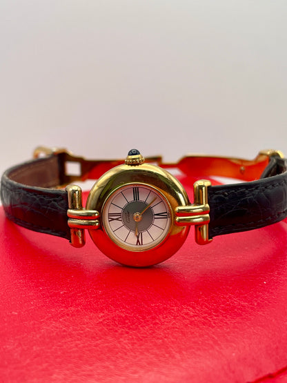 Cartier Colisée Vermeil watch with a gold-tone round case, Roman numeral dial, and black leather strap, presented in a red box.