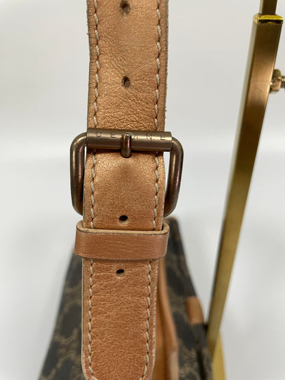 Close-up of the side buckle detail on the shoulder strap of the Celine Macadam Shoulder Bag in denim, highlighting the Celine engraving. and tan leather strap.