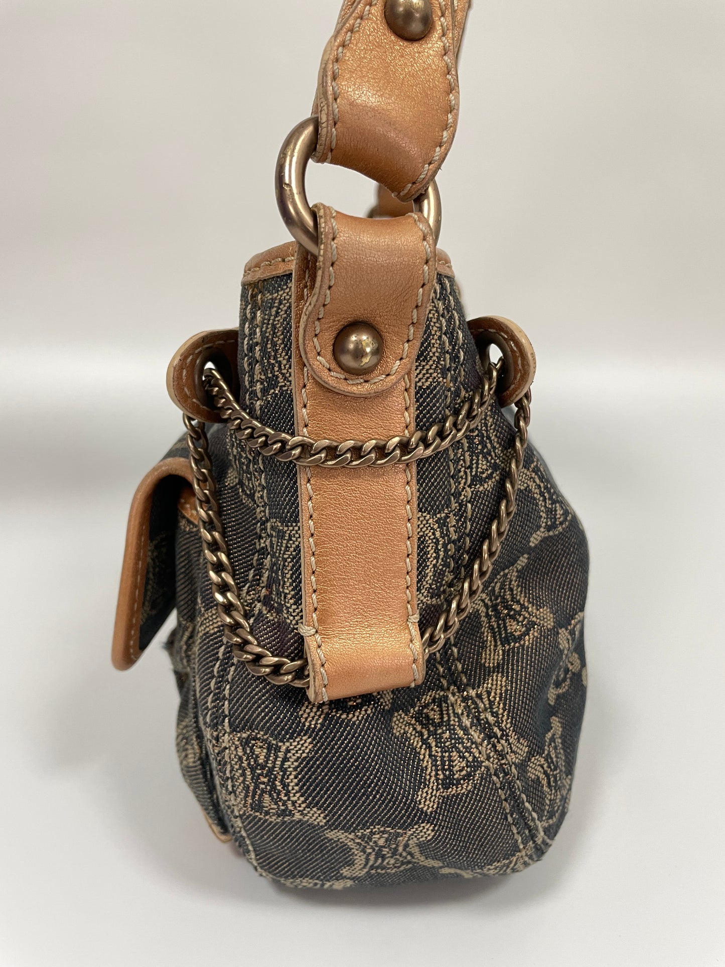 Side view of the Celine Macadam Shoulder Bag in denim with chain detailing and tan leather trim.