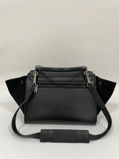 Rear view of the Celine Trapeze Bag in black leather, showcasing a top handle, shoulder strap, and a zippered back pocket.