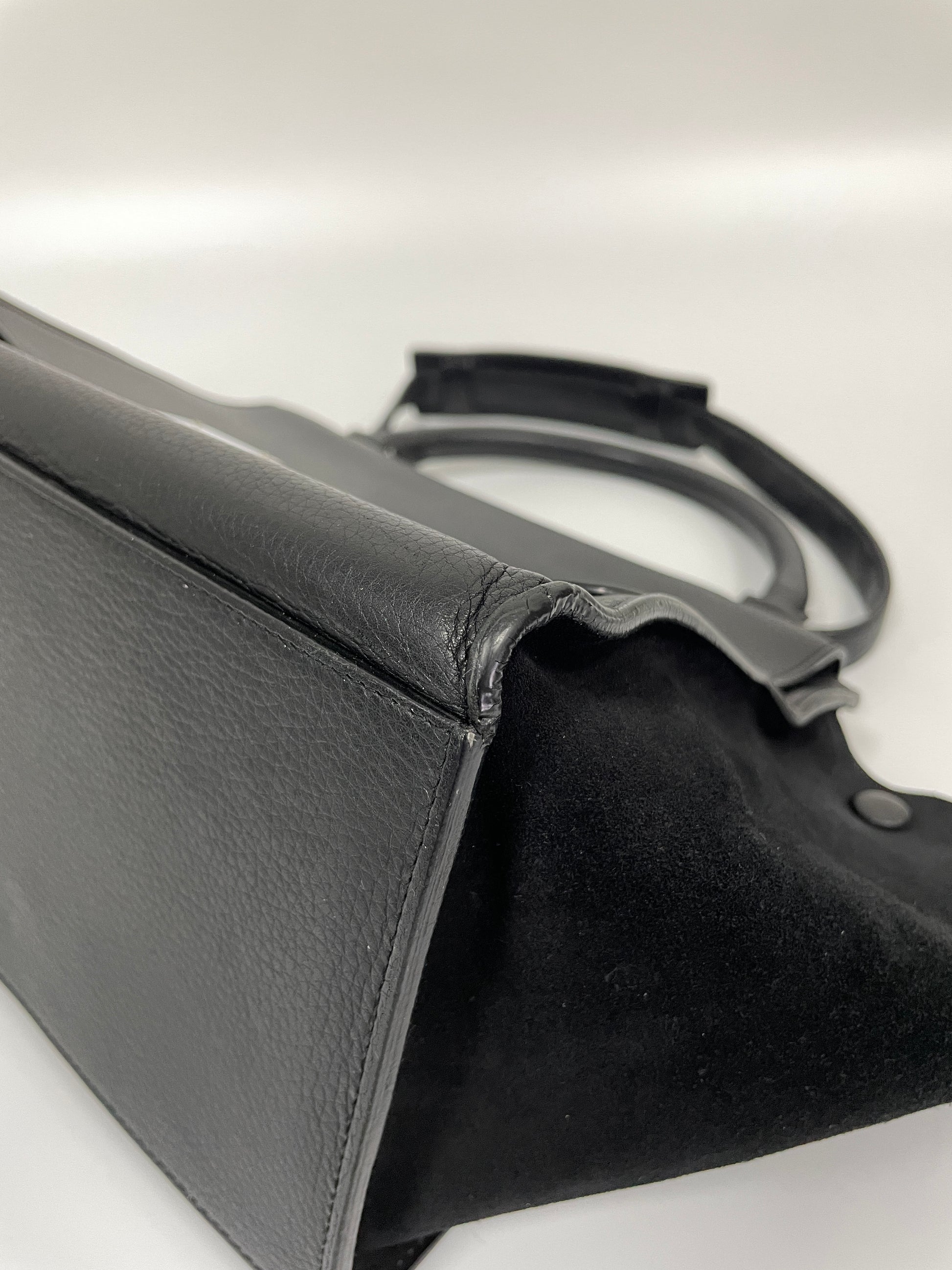 Close-up of a corner of the Celine Trapeze Bag in black leather and velvet trim, showing no wear on the leather.