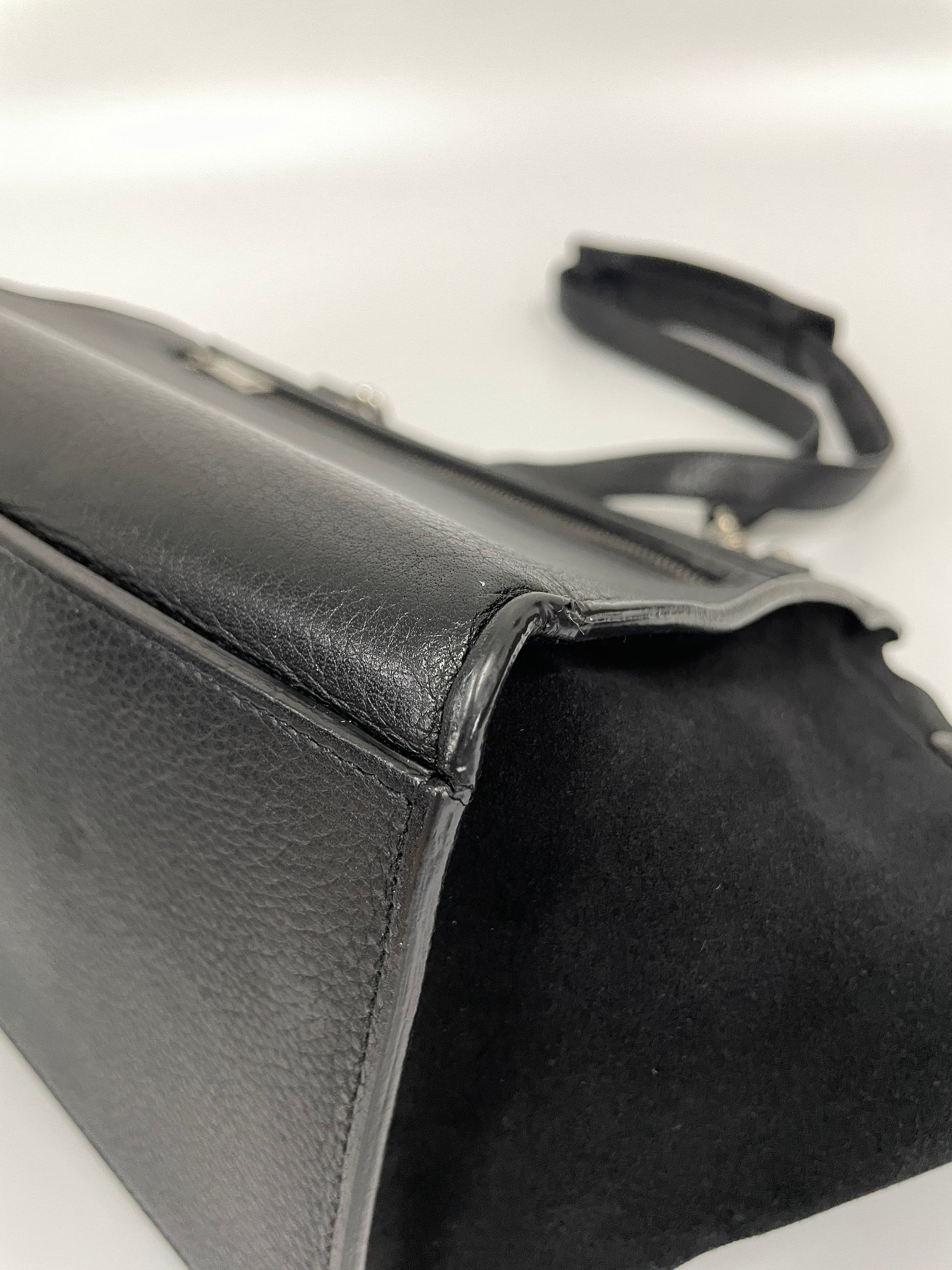 Close-up of a corner of the Celine Trapeze Bag in black leather and velvet trim, showing no wear on the leather.