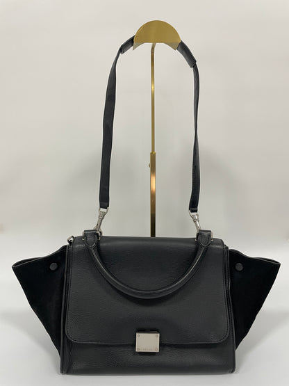 Celine Trapeze Bag in black leather with velvet trim, featuring a front flap and a silver-tone clasp, main front view, showcasing the leather shoulder strap.