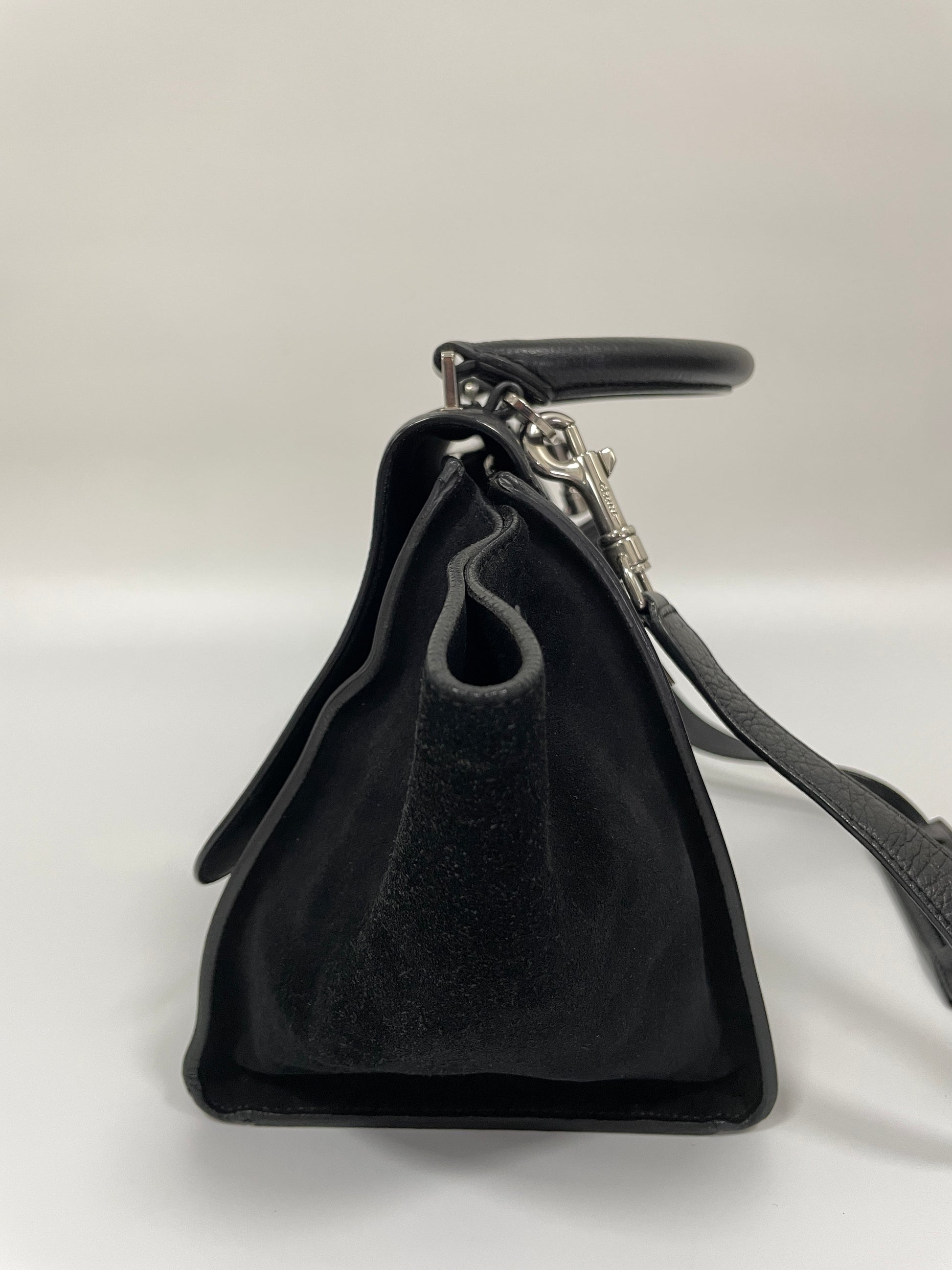 Side view of the Celine Trapeze Bag in black leather with velvet-trimmed wings, highlighting its structured design.