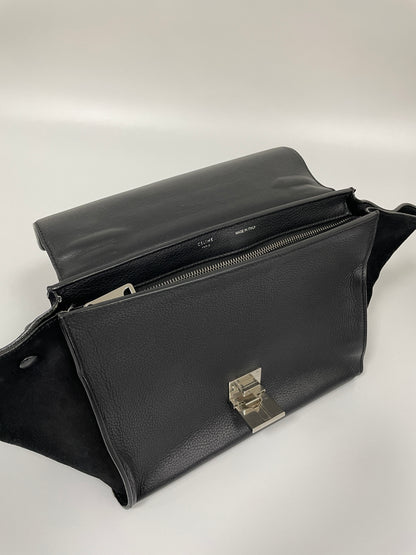 Top view of the Celine Trapeze bag in black leather and velvet trim with the front flap open, showing the structured silhouette and zipper closure.