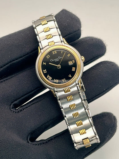 Close-up view of Christian Dior 48.146 women's watch held in hand, highlighting the gold and steel bracelet.