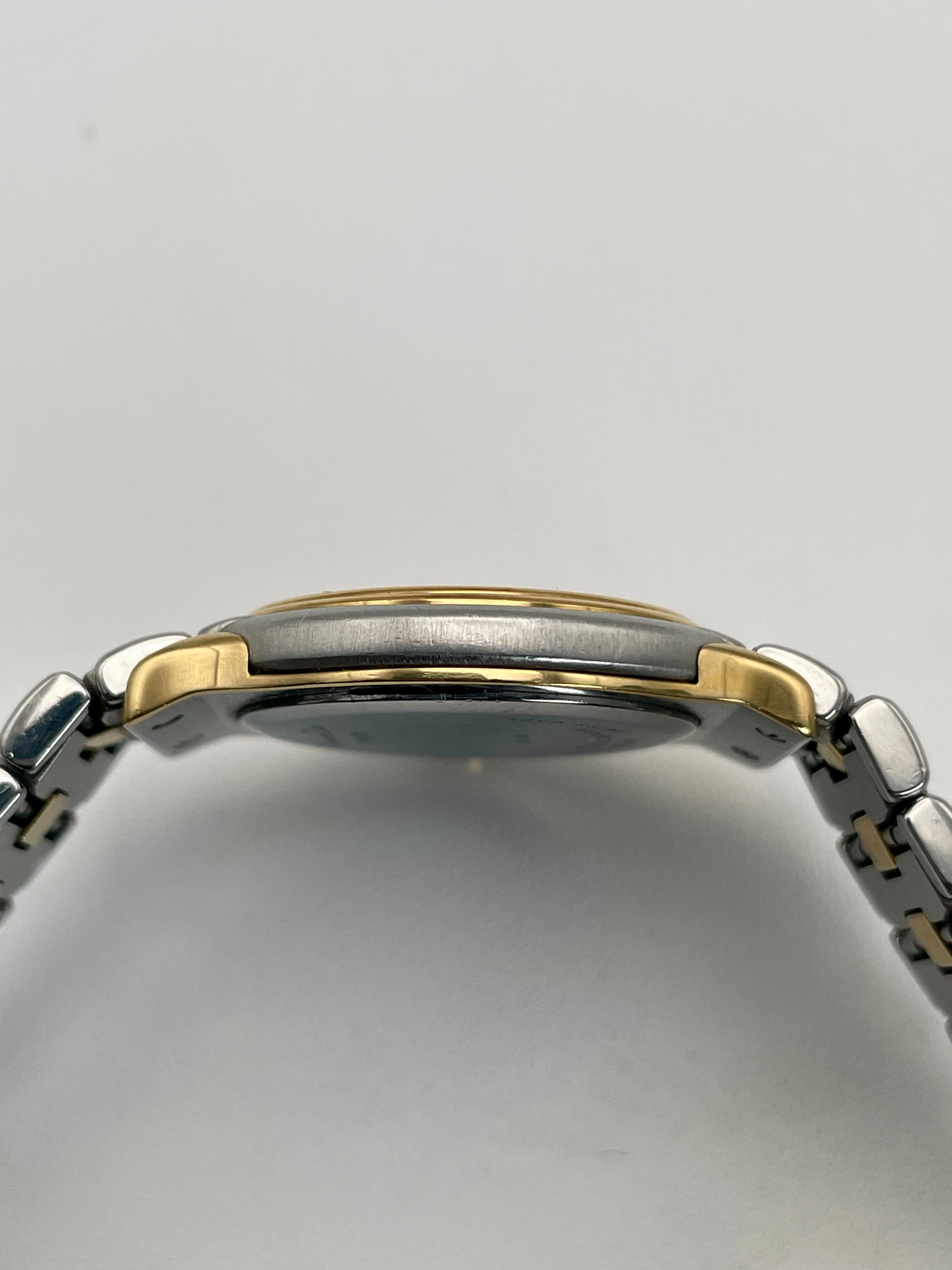 Side view of Christian Dior 48.146 watch showing the polished two-tone case and slim profile.
