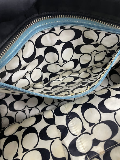 Close-up of the Coach Hampton Tote Bag’s interior pocket, showing the detailed Coach monogram pattern on the lining.