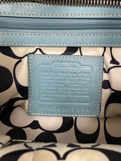 Close-up of the interior Coach creed and label inside the Hampton tote bag, embossed on light blue leather.