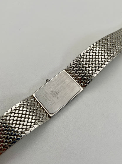 Caseback view of a Credor 2F70 bracelet watch, displaying the engraved details on the silver-tone caseback and the unique mesh bracelet design.