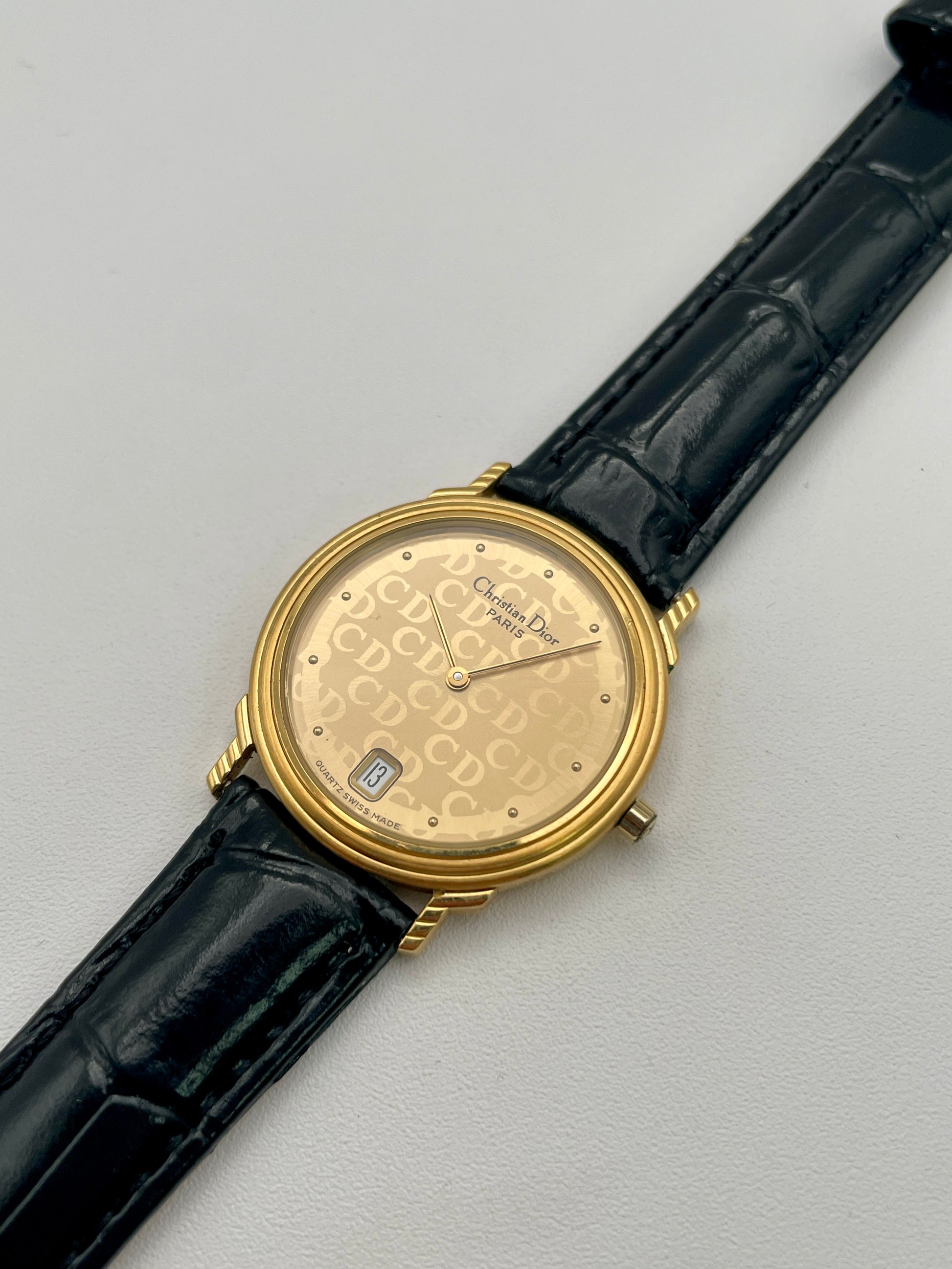 Christian Dior 45.122 vintage women's watch in gold case with gold CD dial and black strap, diagonal angle
