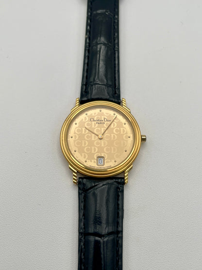 Christian Dior 45.122 vintage women's watch in gold-tone case with CD monogram dial and black leather strap, front view
