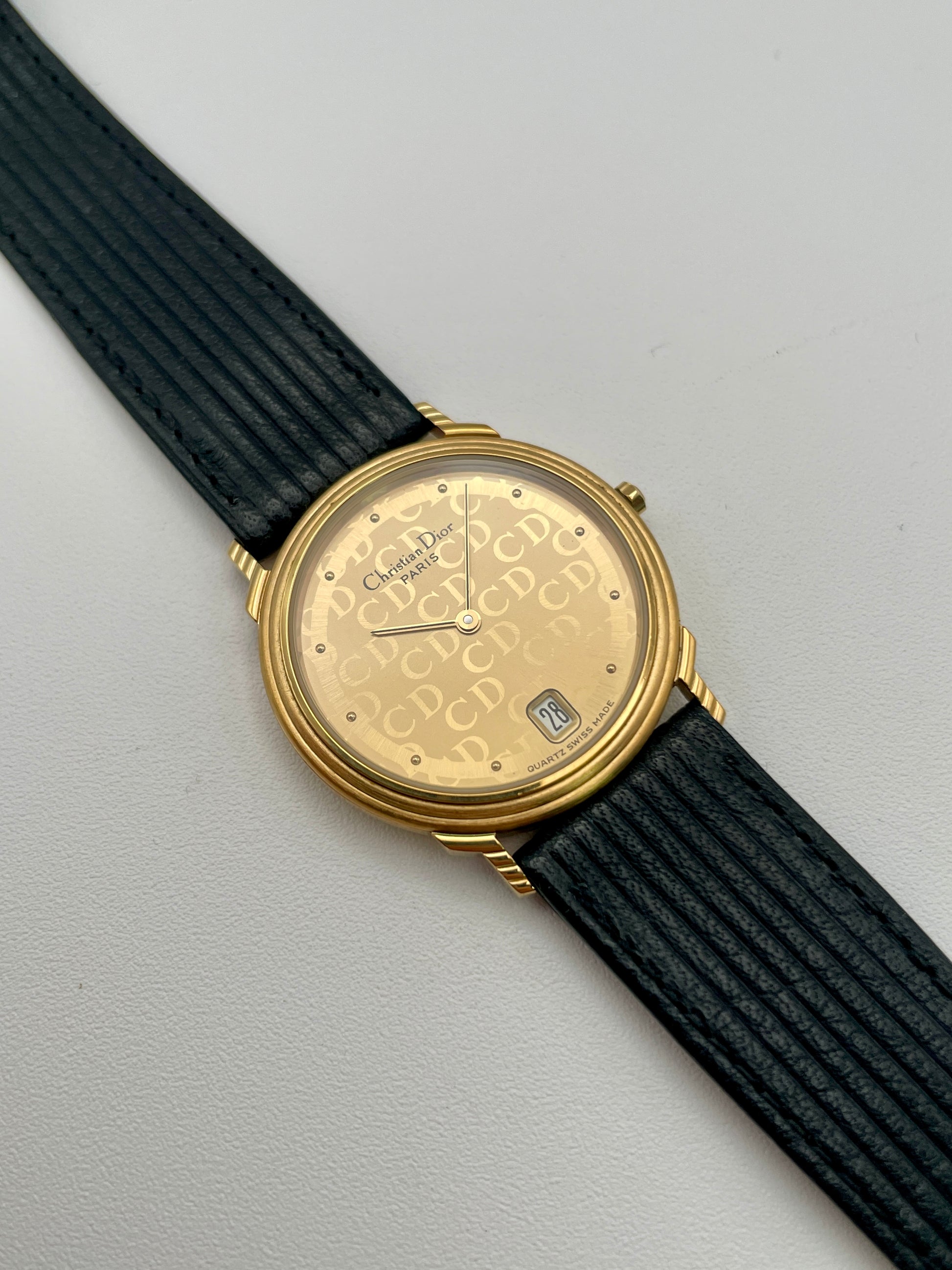 Christian Dior 45.122 vintage women's watch in gold with monogram dial and black ribbed strap, shown inside original Dior box
