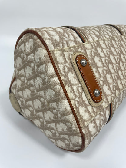 Bottom corner view of Christian Dior Trotter Romantique bag in beige leather and canvas showing the reinforced leather corners.