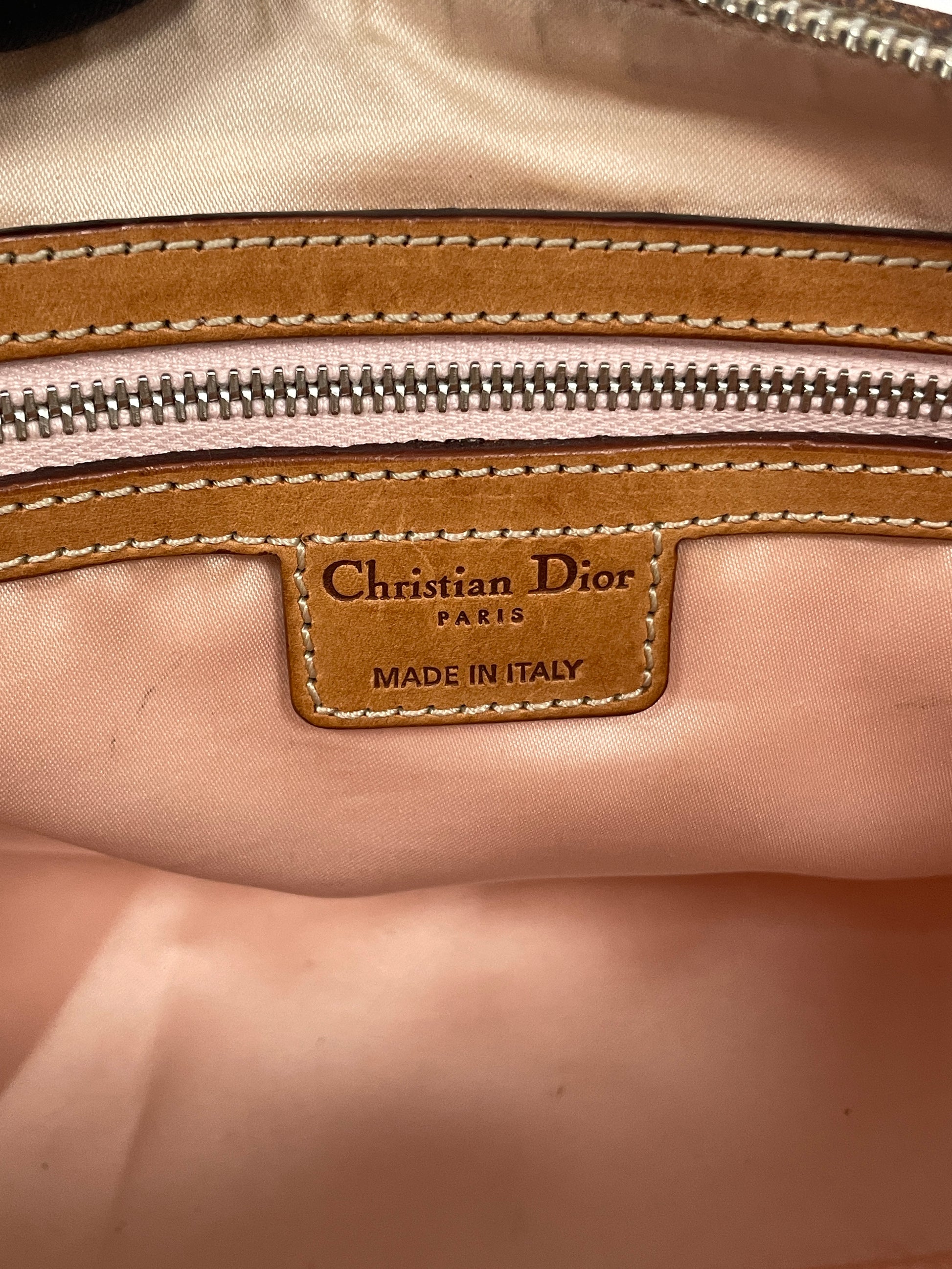 Close-up of the Christian Dior label inside the Dior Trotter Romantique Bag in beige leather and canvas, marked "Christian Dior Paris - Made in Italy."