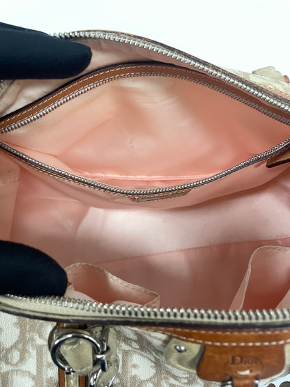 Interior pocket view of the Christian Dior Trotter Romantique Bag in beige leather and canvas, showcasing pink lining and zipper pocket.