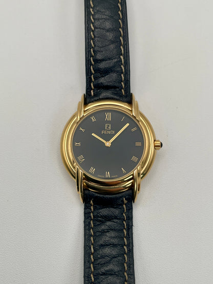 Front view of the Fendi 300J watch showing black dial with gold Roman numerals and triple lug design.