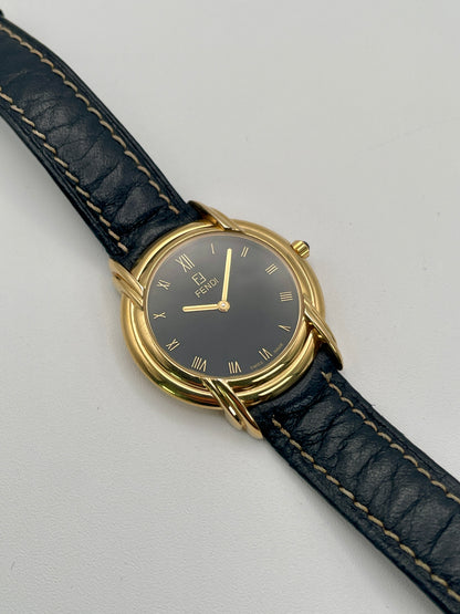 Front view of the Fendi 300J watch showing black dial with gold Roman numerals and triple lug design.