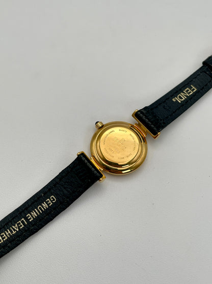 Back view of the Fendi 320L watch showcasing the engraved details on the gold-tone back, paired with a black leather strap