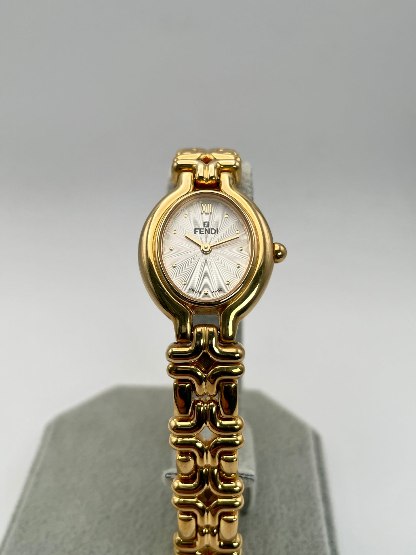 Front view of the Fendi 640L Vintage Women's Watch, showcasing the white guilloché dial with Roman numerals and dot markers inside a gold-tone oval case.