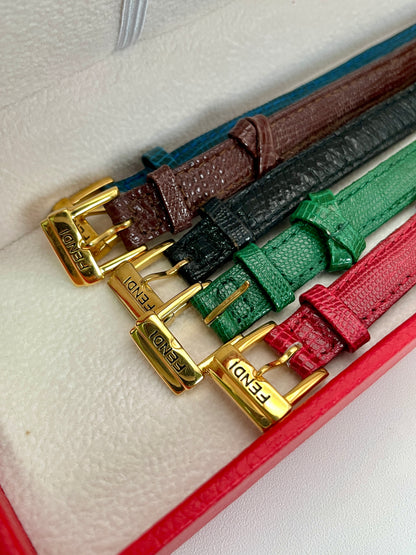 Detailed view of the Fendi 640L gold watch and its additional interchangeable leather straps in various colors.