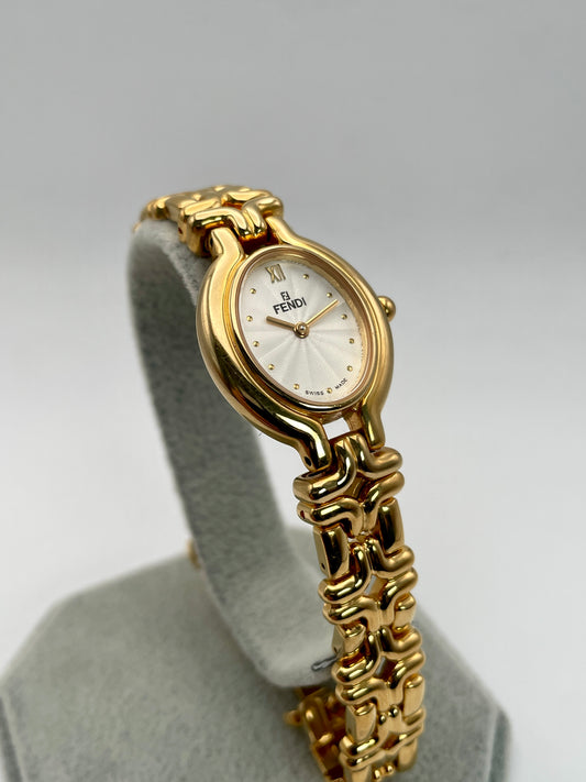 Main angle view of the Fendi 640L Vintage Women's Watch, featuring a gold-tone oval case and a white guilloché dial, paired with a unique sculptural link bracelet.