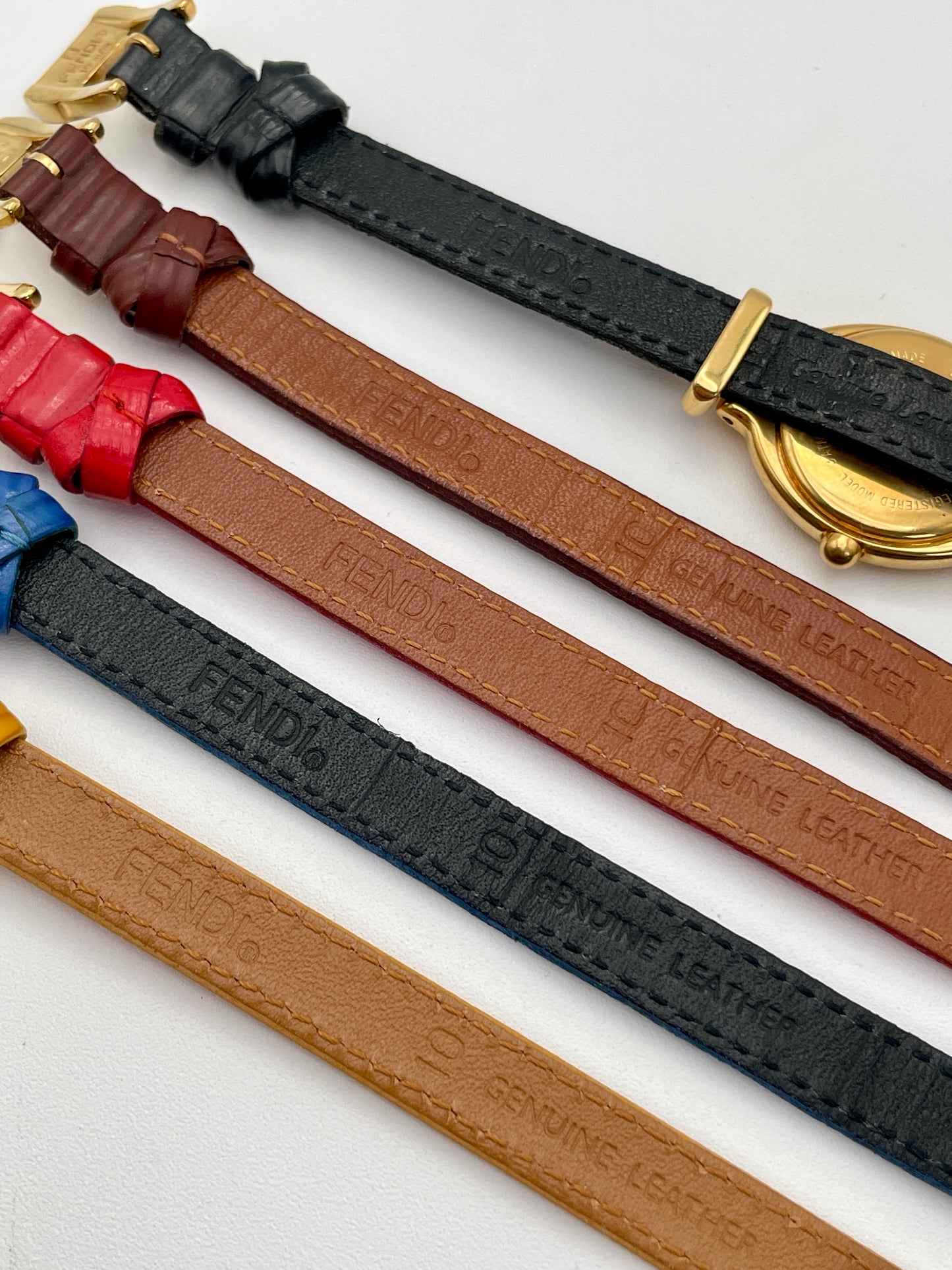 View of Fendi 640L watch with gold case and full set of multi-colored leather straps.