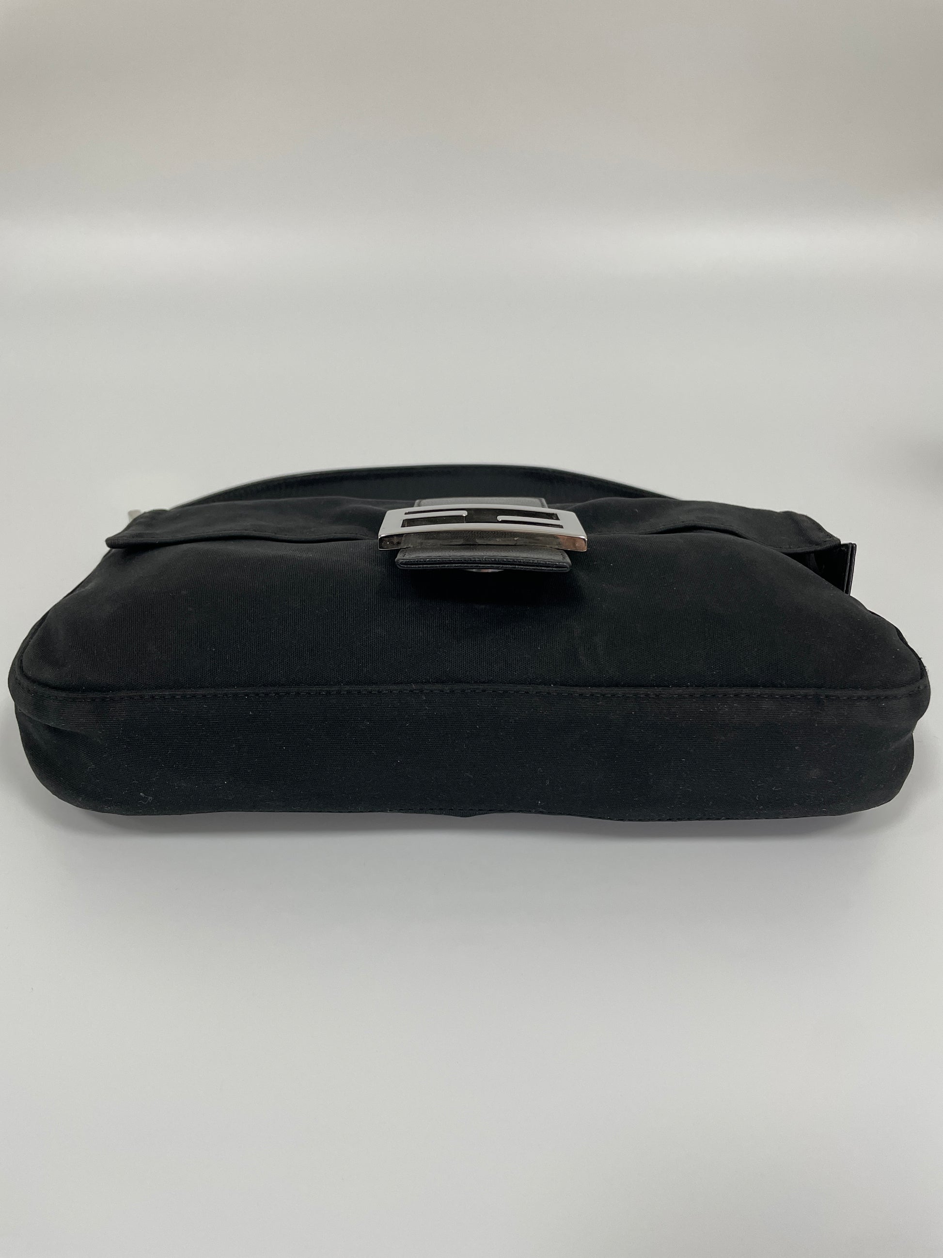 Bottom view of the Fendi Baguette Bag in black neoprene, displaying the flat base.