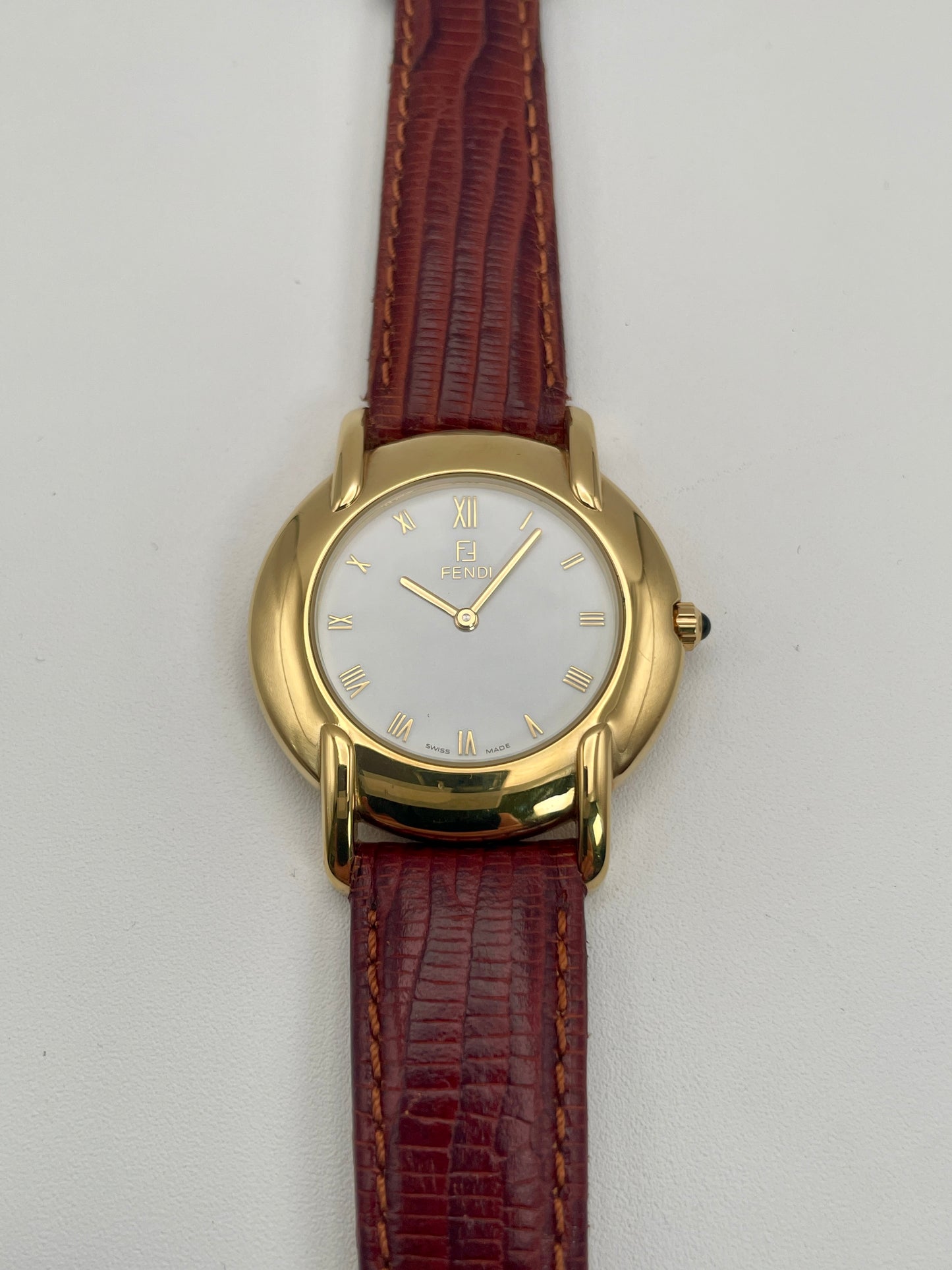 Front view of the Fendi Orologi 410G vintage watch in gold with a white dial and red leather strap.