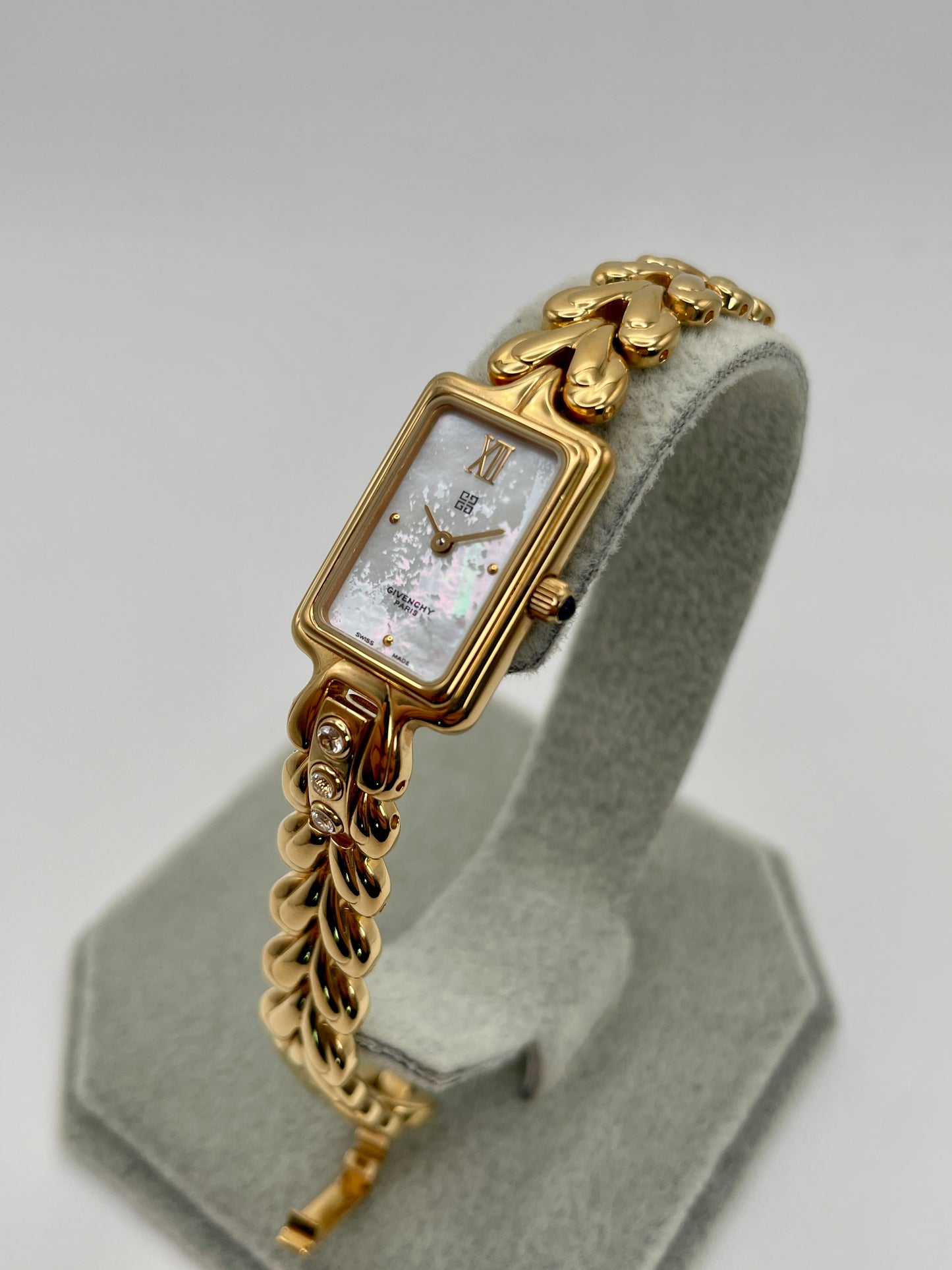 Diagonal angle showcasing the Givenchy Bambou watch’s mother-of-pearl dial and sculpted gold-tone bracelet