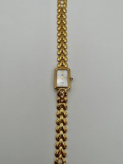 Flatlay of the Givenchy Bambou gold watch showing the full bracelet and dial facing up