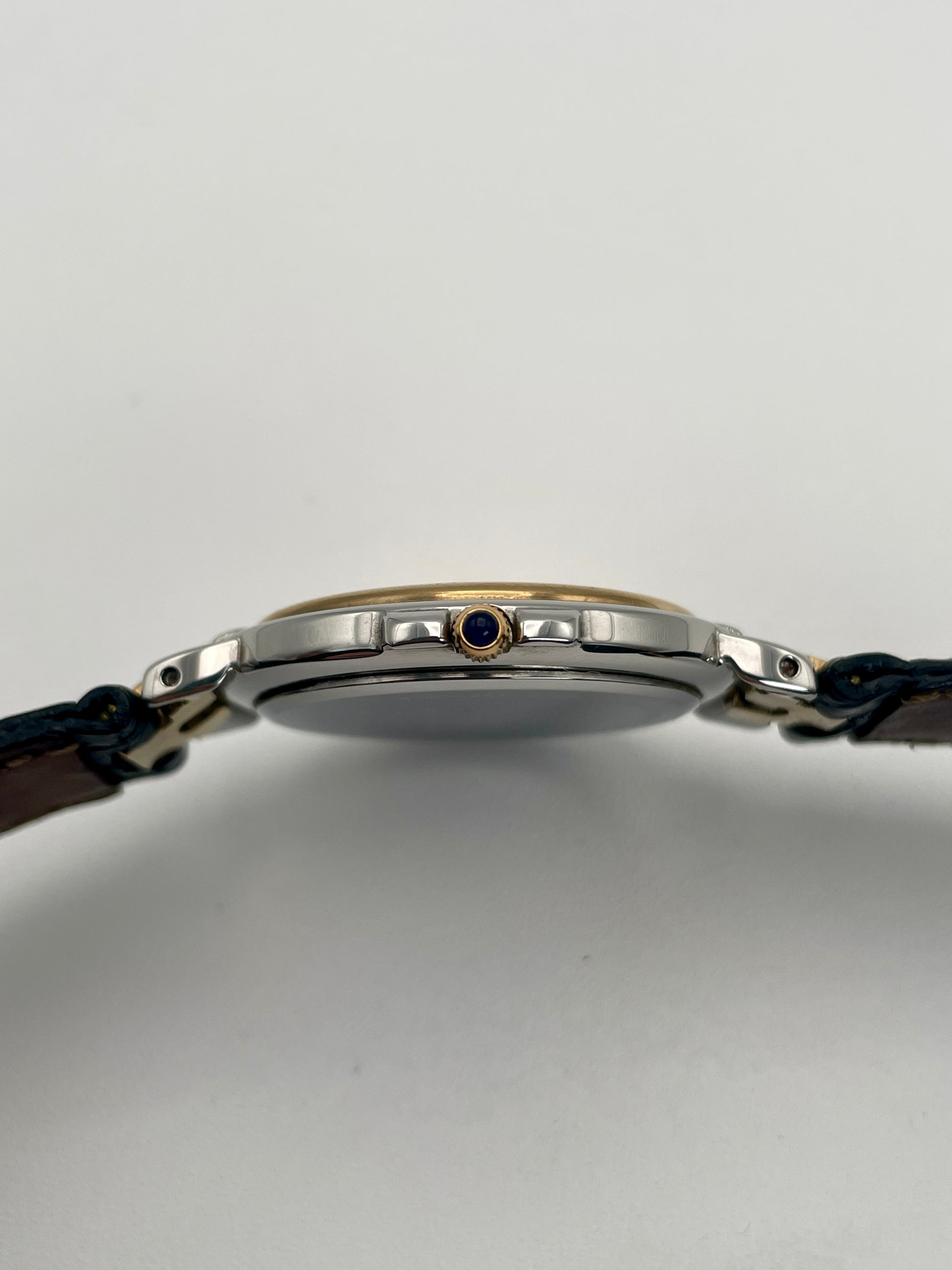 Side view of the Givenchy Chenonceaux vintage watch focusing on the crown and the two-tone case in gold and steel.