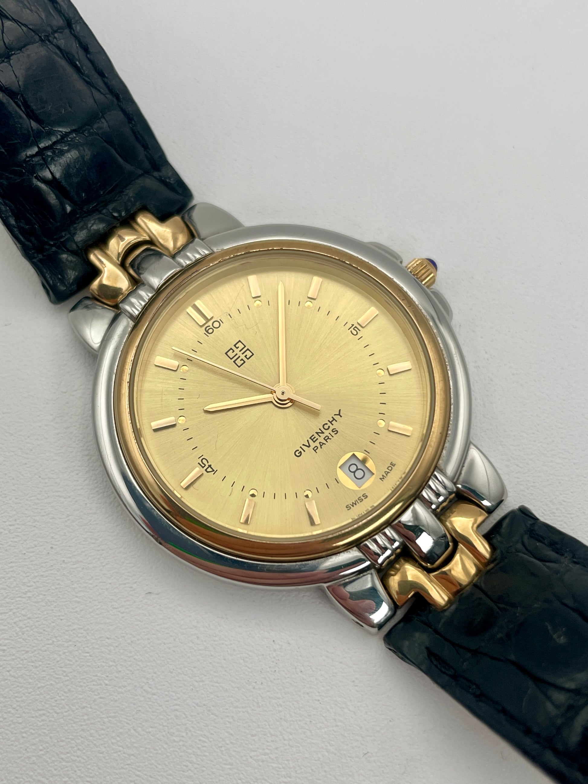 Main view of Givenchy Chenonceaux vintage ladies' watch with gold-tone dial and two-tone case in gold and steel, paired with a black leather strap.