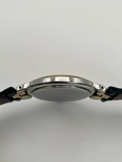 Side case view of the Givenchy Chenonceaux vintage watch showing the slim profile of the stainless steel and gold case.