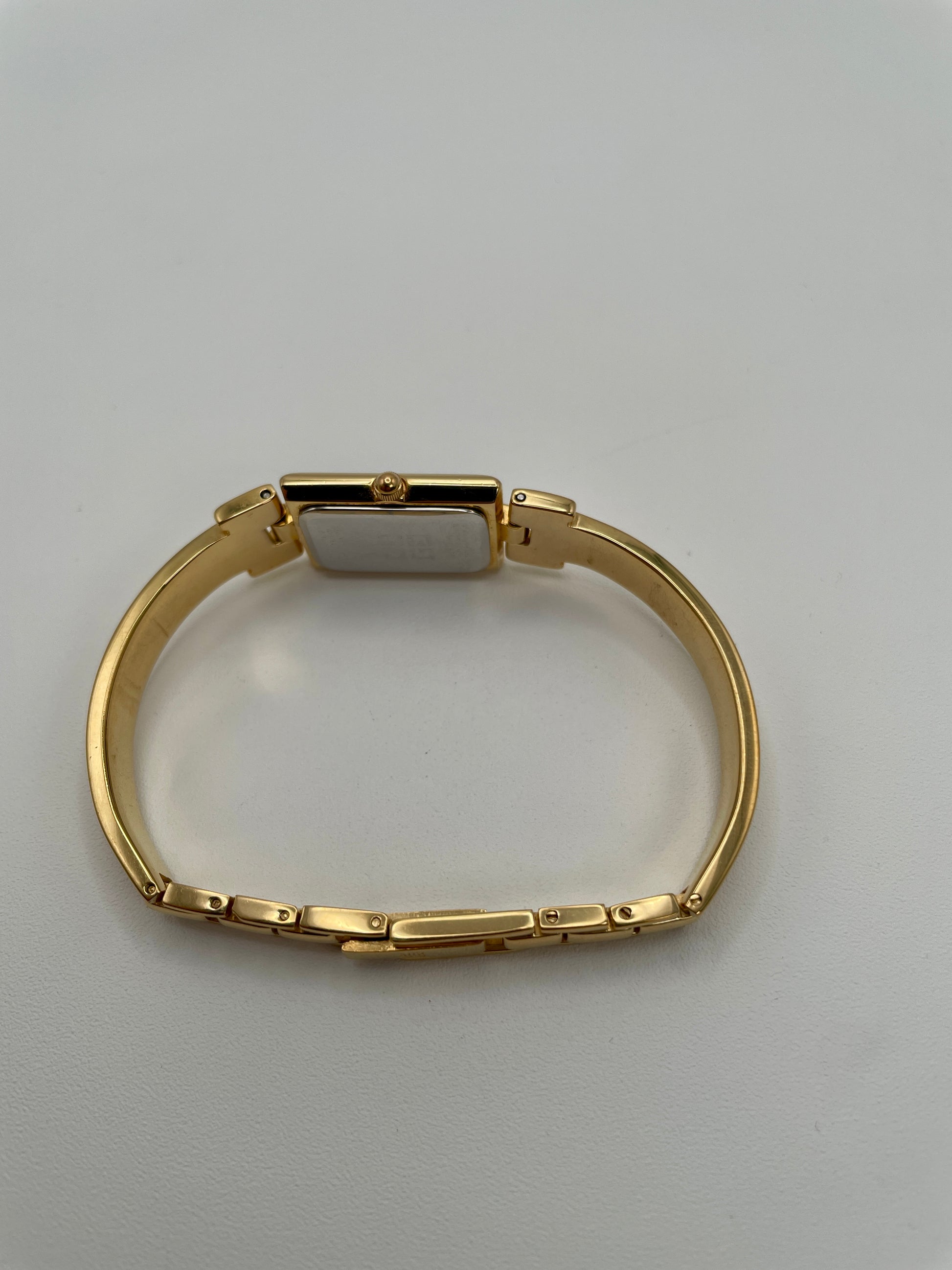 Side view showing the gold crown and bracelet links of the Givenchy Millesime from the left