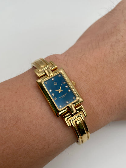Wrist shot of the Givenchy Millesime watch showing the blue dial and gold-tone case from the front