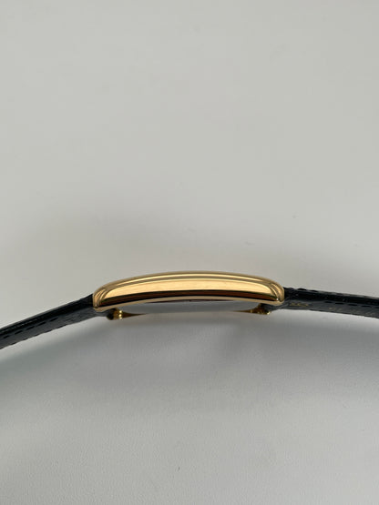 Side view of Grovana Tank Dual Time watch with a gold-tone rectangular case and black leather strap.