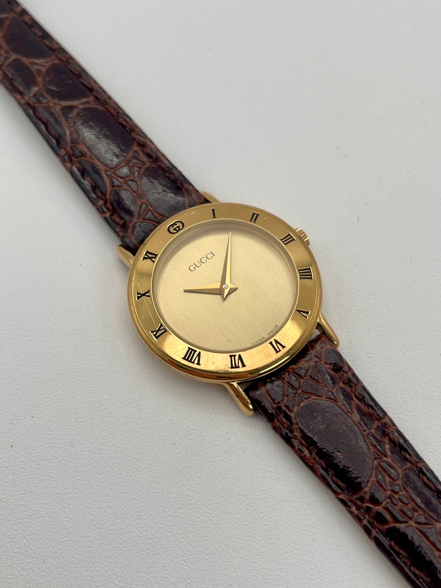 Main view of the Gucci 3000.2.L vintage ladies' watch in gold with a brown leather strap and Roman numerals bezel.