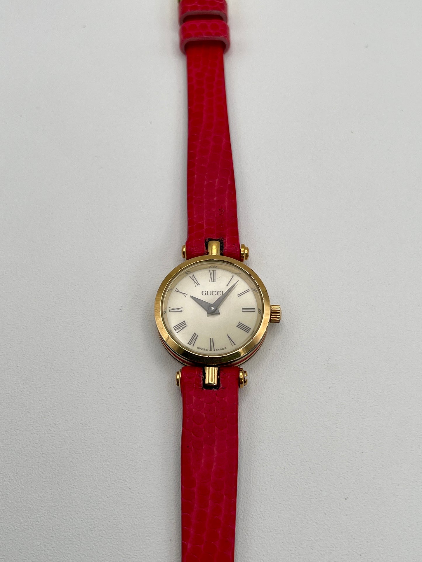 Front view of the Gucci Sherry Line Vintage Women's Watch in gold-tone case with red leather strap, showcasing the Roman numeral dial.