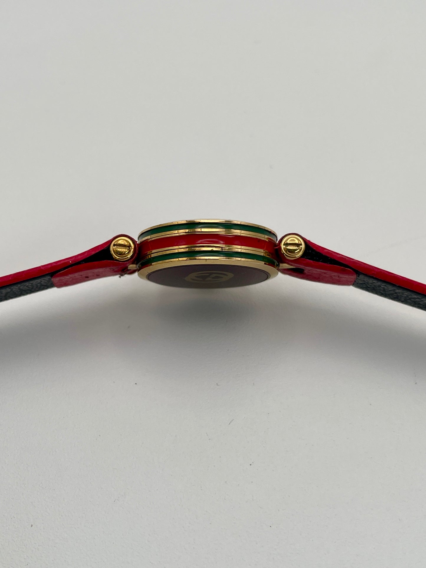 Horizontal side profile of the Gucci Sherry Line watch showing the enamel detailing and gold crown.