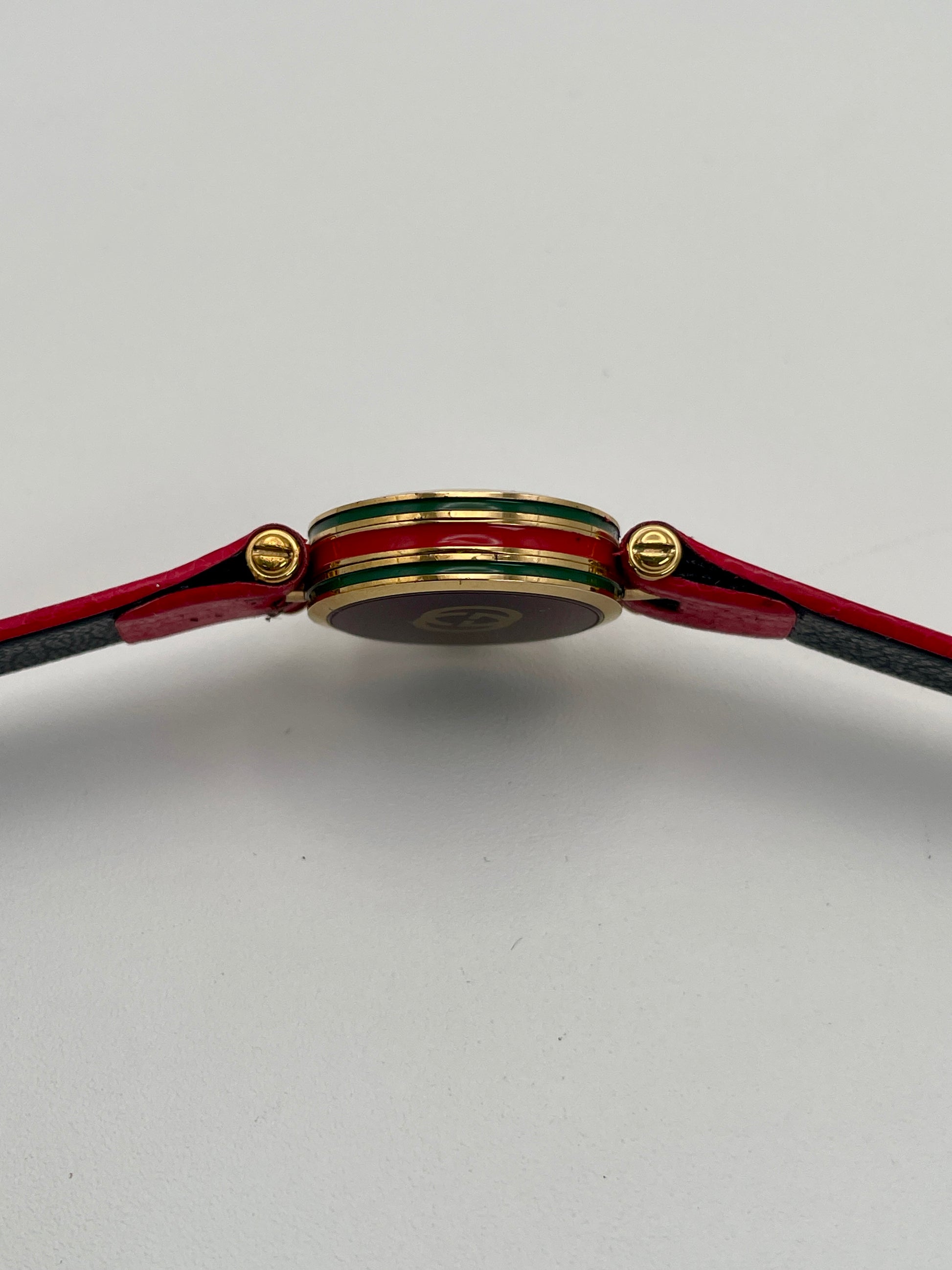 Horizontal side profile of the Gucci Sherry Line watch showing the enamel detailing and gold crown.