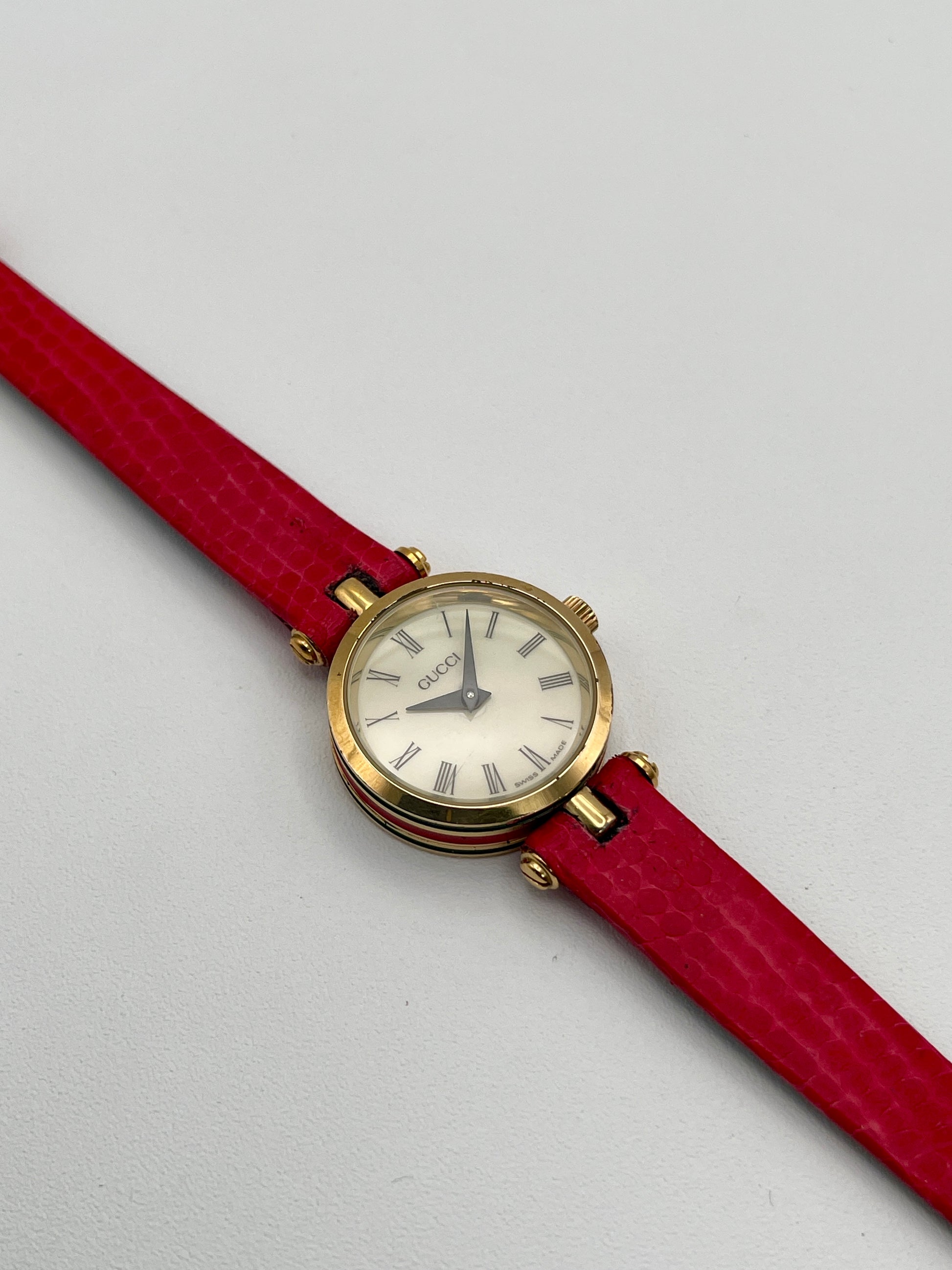 Gucci Sherry Line Vintage Women's Watch in gold-tone case with red leather strap, showcasing the Roman numeral dial.