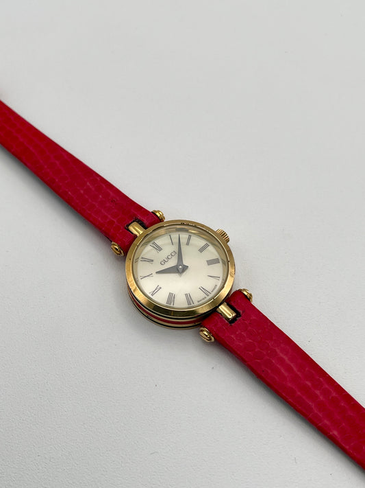 Gucci Sherry Line Vintage Women's Watch in gold-tone case with red leather strap, showcasing the Roman numeral dial.