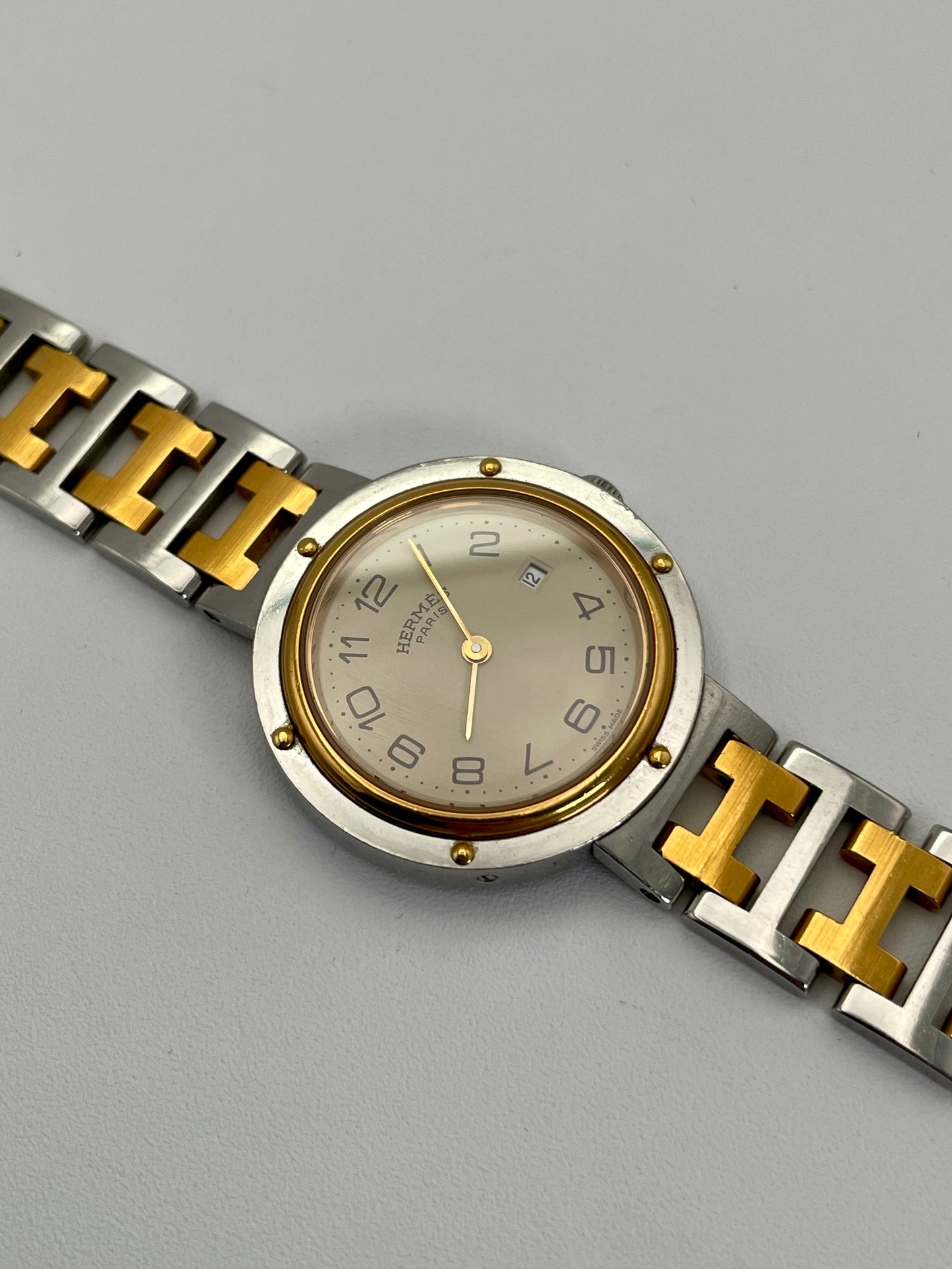 Main view of a Hermes Clipper 30mm two-tone watch with a stainless steel and gold bracelet. The silver dial features Arabic numerals and a date window at the 3 o'clock position.