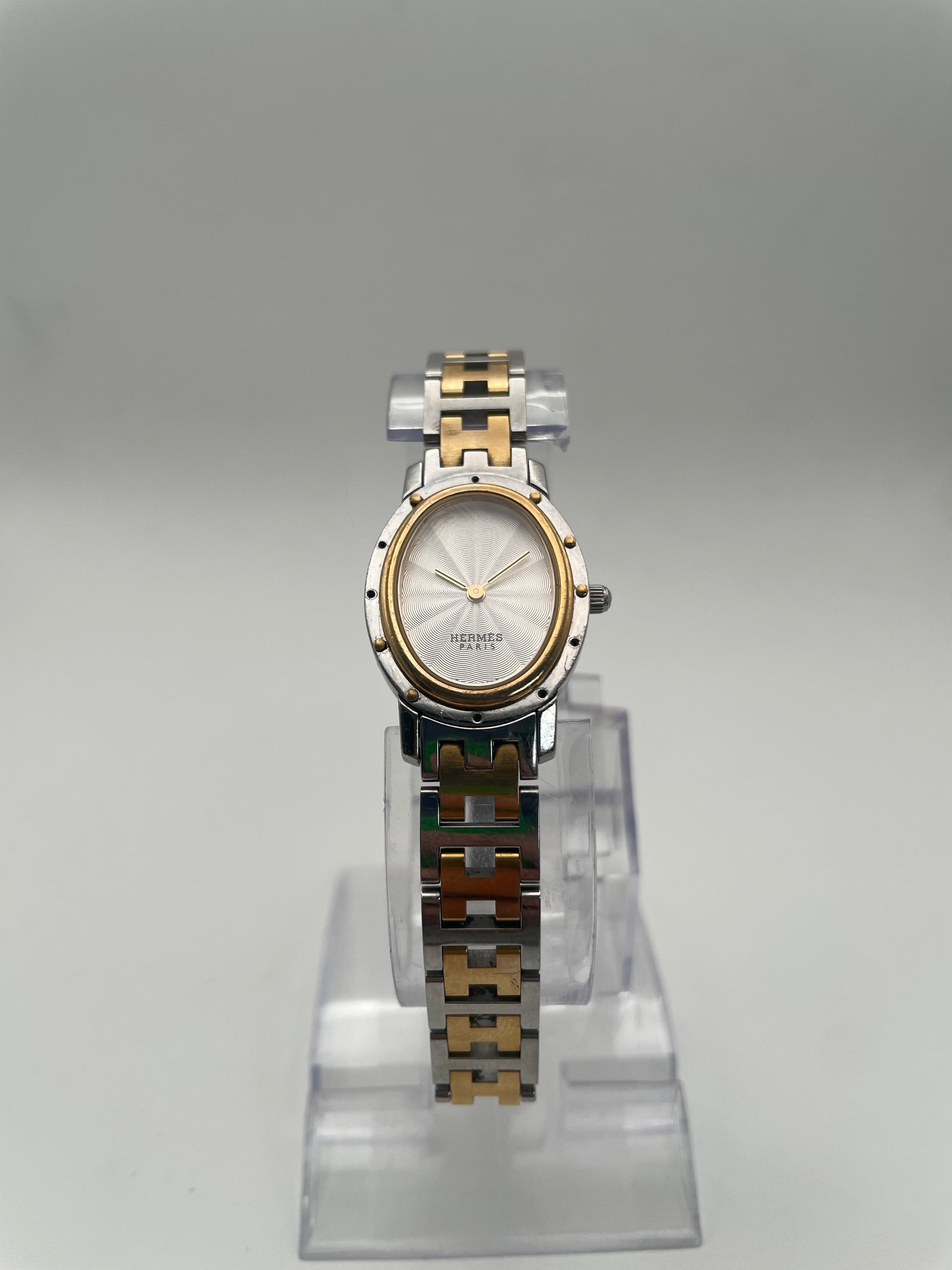 Front view of Hermès Clipper Oval Vintage Ladies Watch in two-tone stainless steel with gold accents, featuring a silver guilloché dial.