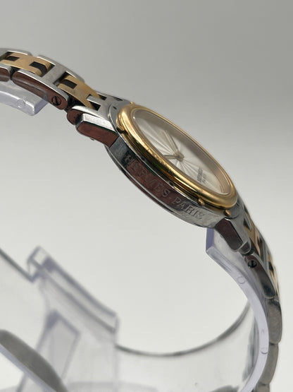 Side view of the Hermès Clipper Oval Vintage Ladies Watch showing the gold bezel on the stainless steel case.