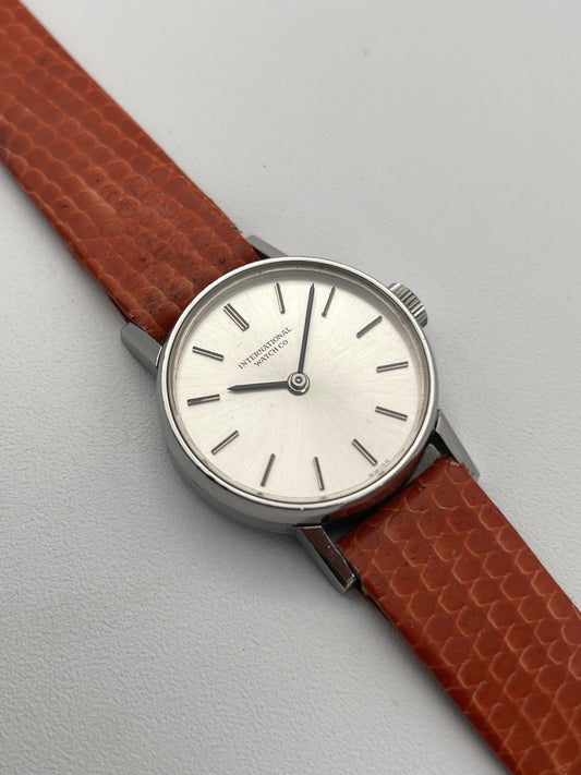 View of a Vintage IWC Ladies Caliber 41 watch with a silver dial and orange leather strap.