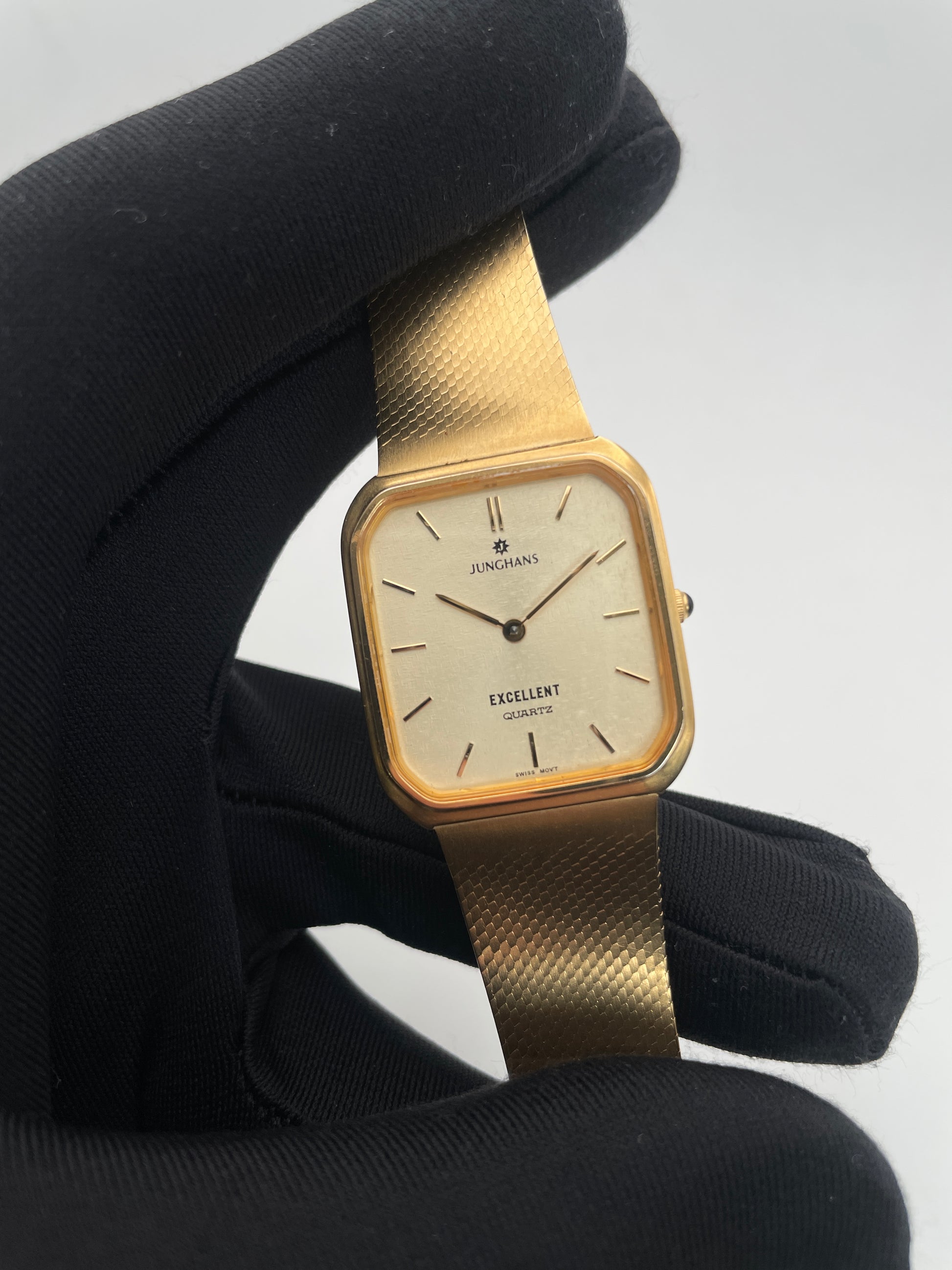 Close-up view of Junghans Excellent vintage quartz watch showing the gold-tone square case and dial.