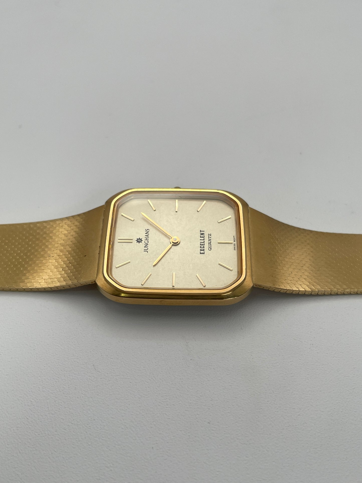 Side caseback view of Junghans Excellent vintage quartz watch showing the gold-tone bracelet and stainless steel caseback.