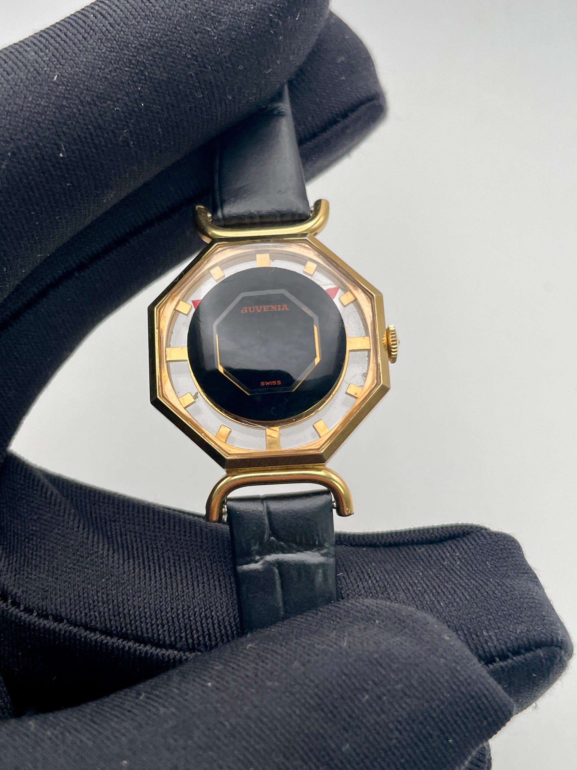 Close-up view of the watch held in hand, highlighting dial design and crystal detail

